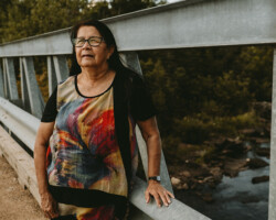 Ethel LaValley, Whitney, age 71. Ethel stands on the bridge that she crossed every day as a child in Whitney.
