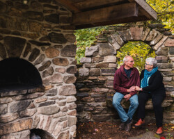 Lesley MacDonald and
Peter Ritchie, Combermere. Ages: Ledley 69 , Peter 67. Peter and Lesley sit in the stone garden (complete with stone oven), that Peter built.