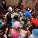 Many children gather around a mosaic.