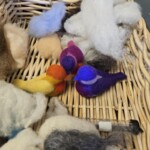 Needled felted birds in a basket.