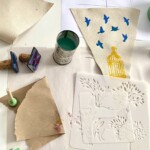 Stencils and painted canvas on a table.