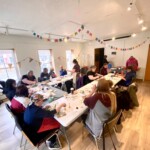 People paint at a circle of tables.