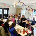 A large group of people make art together.